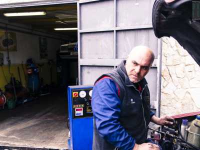 Il 45enne Gennaro intento  a riparare un'automobile nella sua autofficina 
